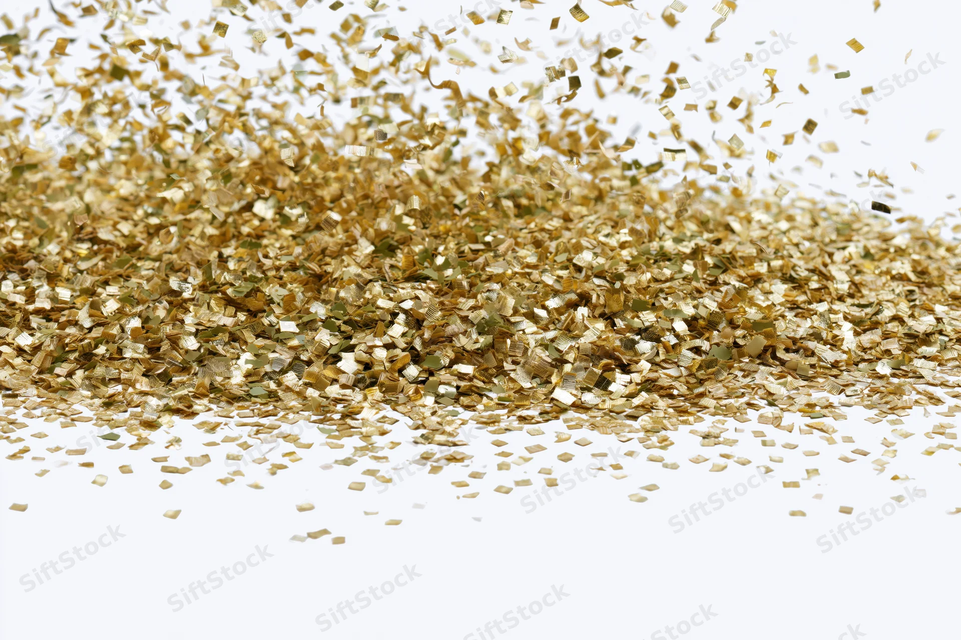 Gold metallic confetti pieces falling and scattering mid-air on white background