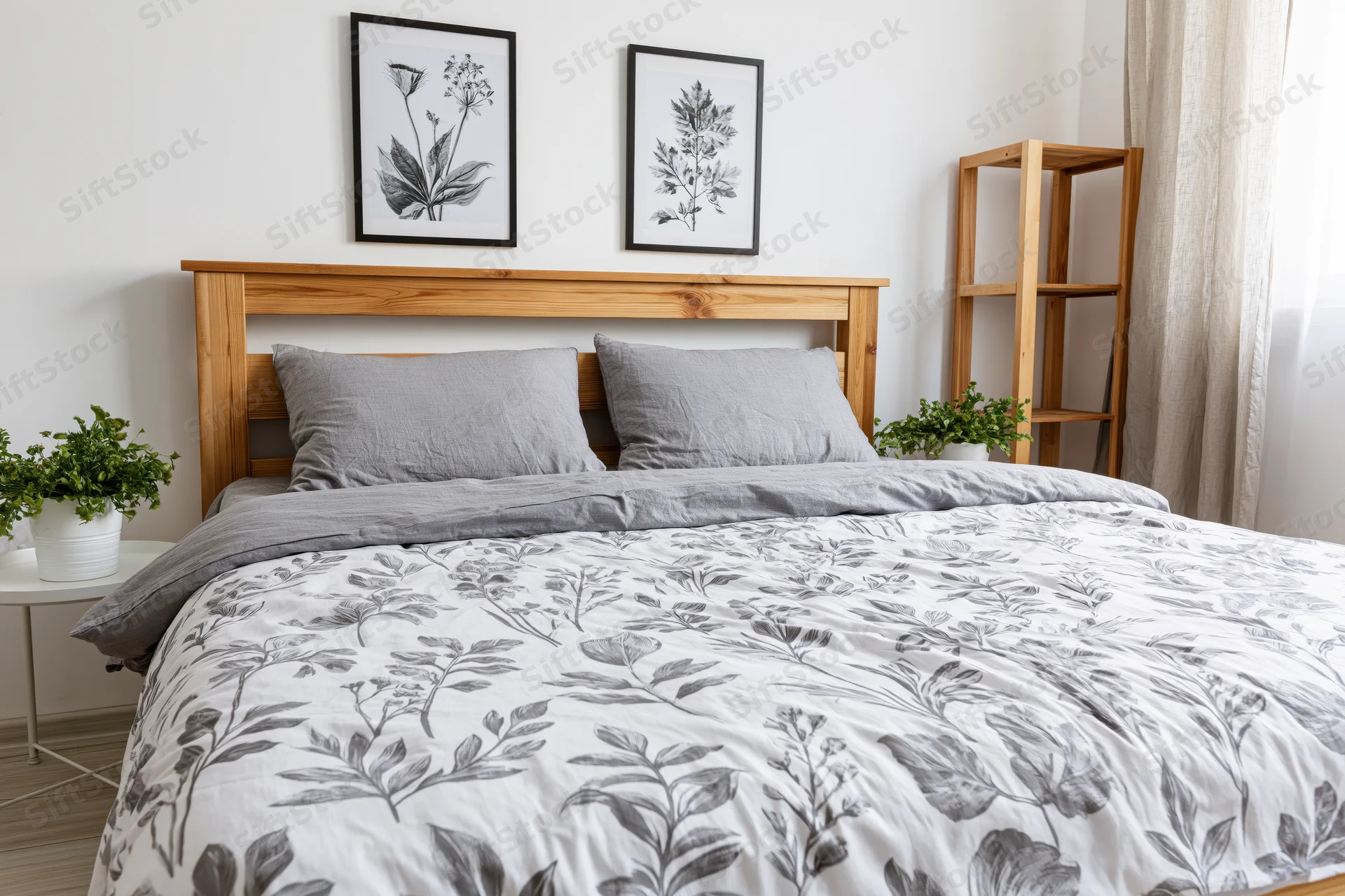 Double bed with wooden headboard and gray floral bedding in minimalist scandinavian bedroom