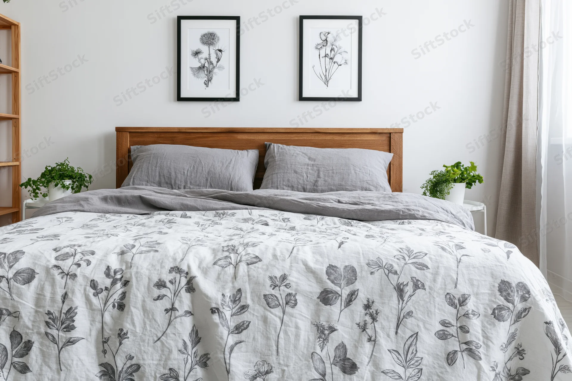 Double bed with wooden headboard and floral bedding in a minimalist bedroom