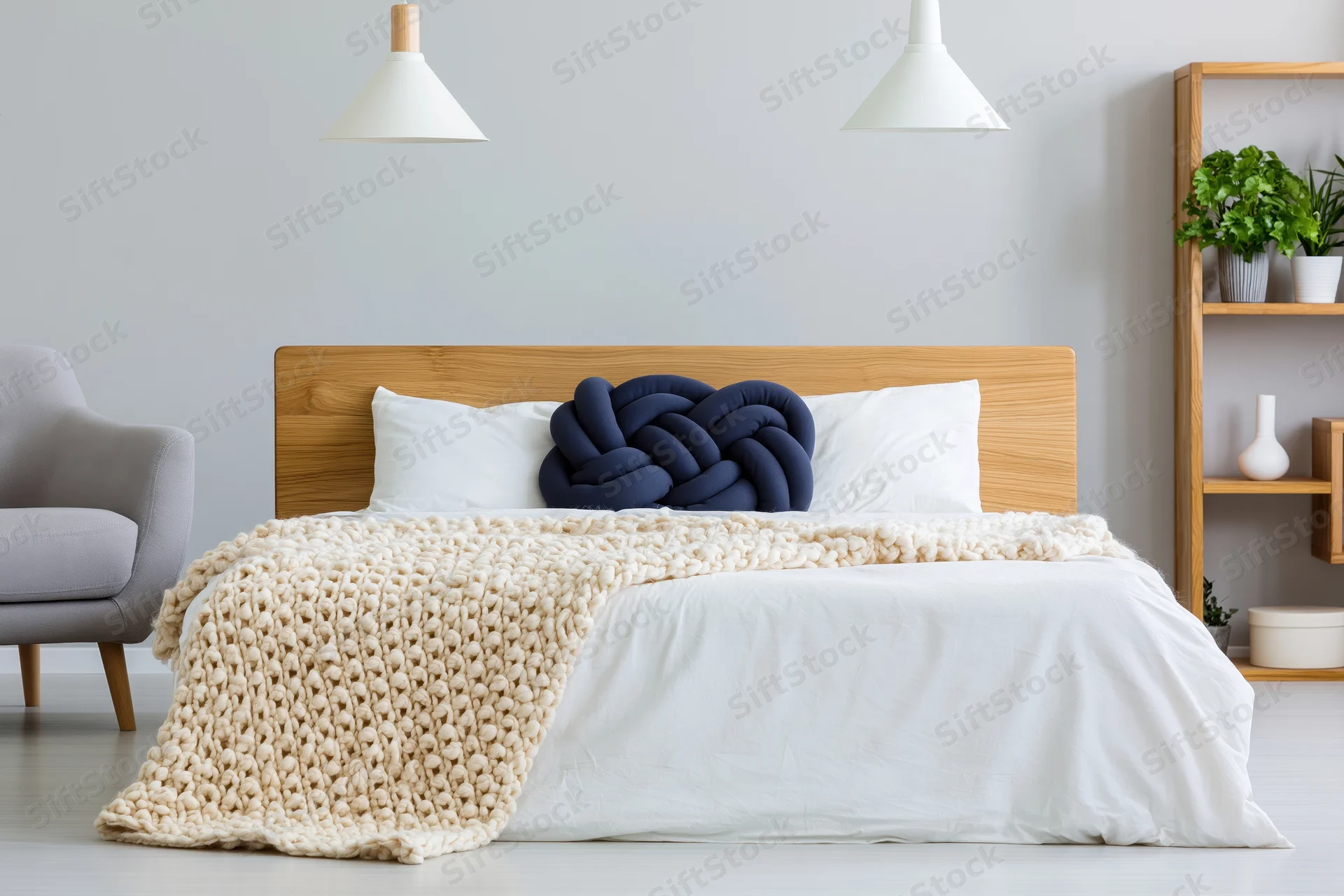 Minimalist scandinavian bedroom with wooden headboard, white bedding, knitted blanket, and pendant lamps