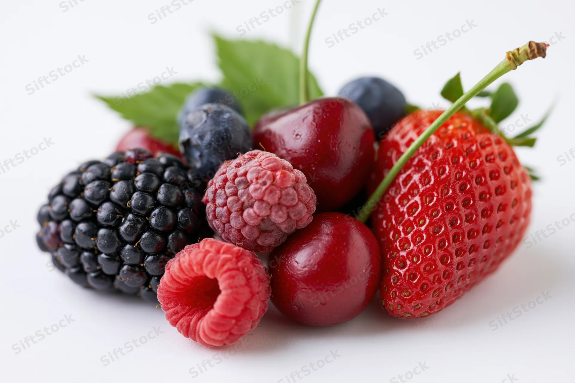Mixed fresh berries arranged in a cluster on a white surface