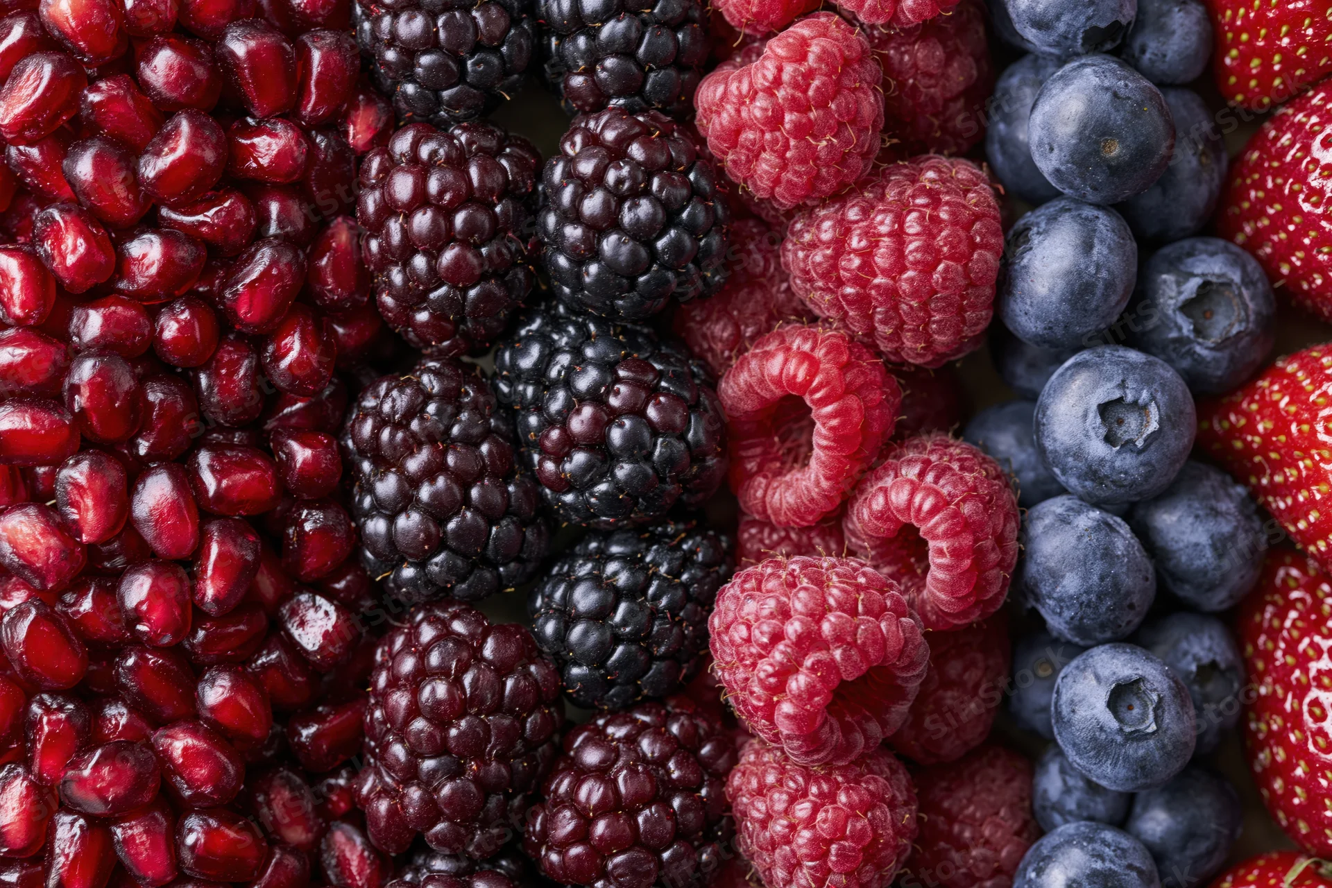 Mixed fresh berries arranged in vertical columns filling the frame