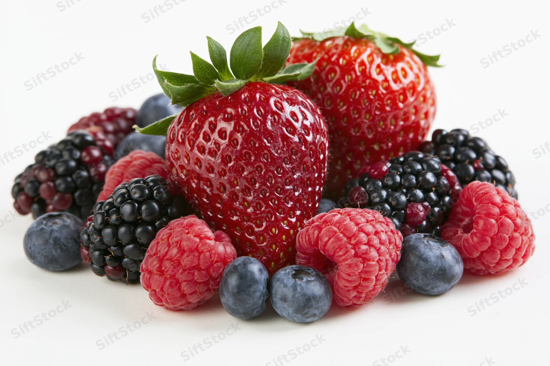 Mixed fresh berries arranged in a cluster on a white surface
