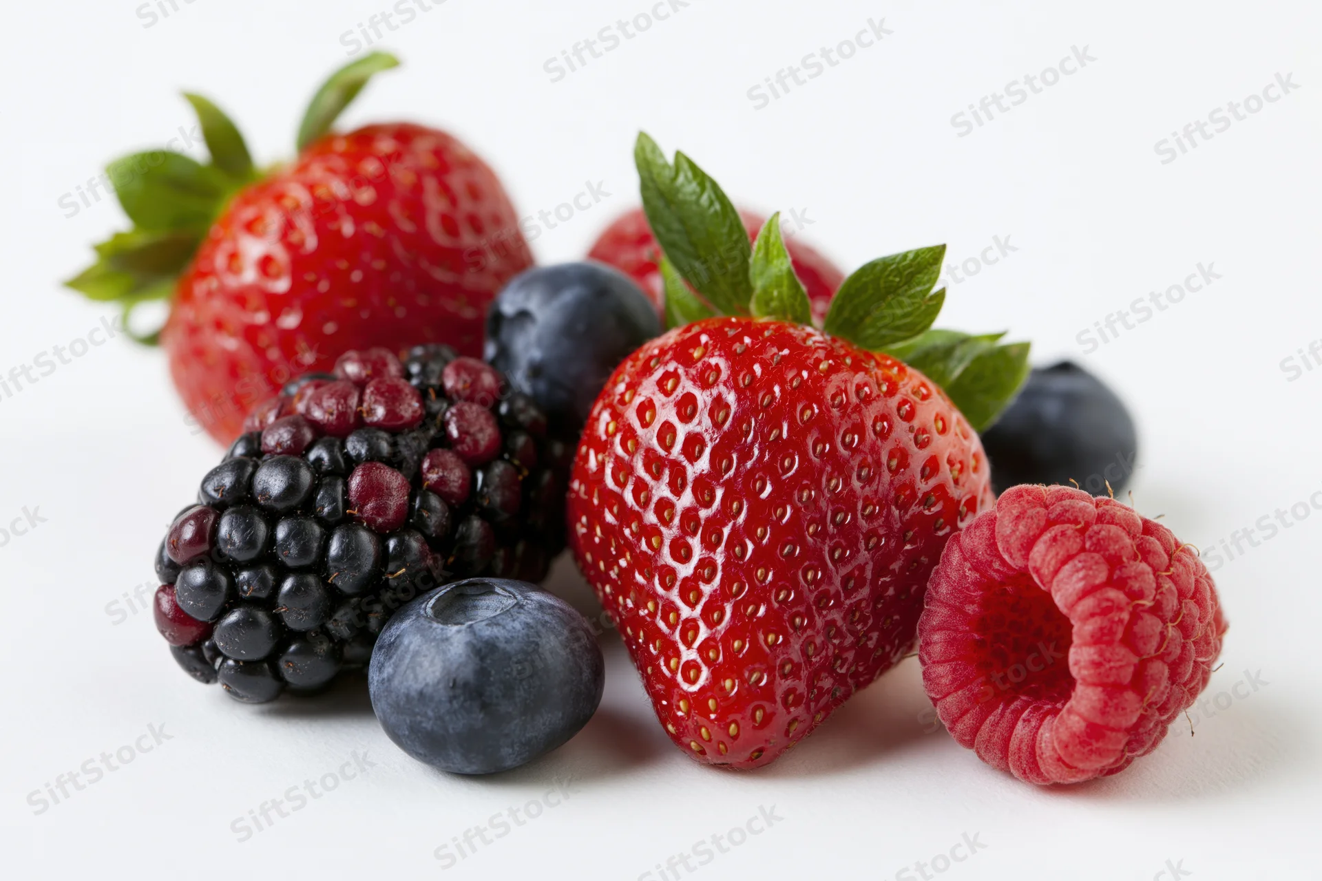 Mixed fresh berries arranged on a clean white surface