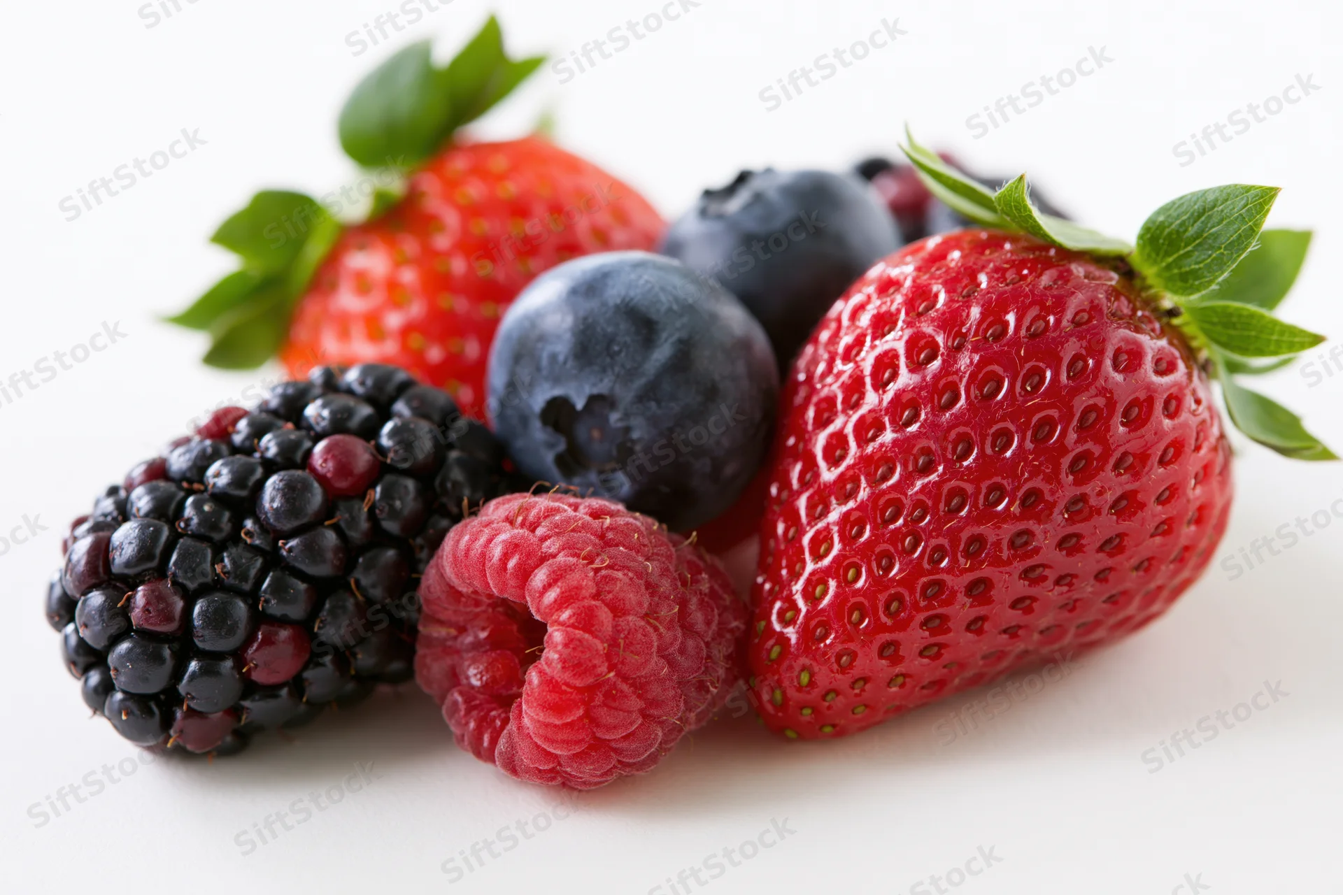 Mixed fresh berries arranged on a white surface
