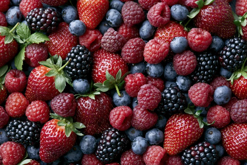 Overhead flat lay of mixed fresh berries covering the entire frame