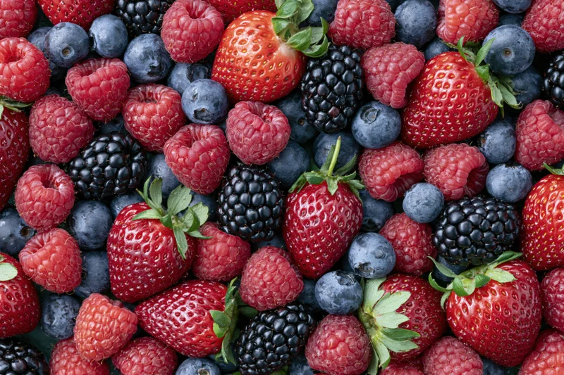 Overhead flat lay of mixed fresh berries covering the entire frame