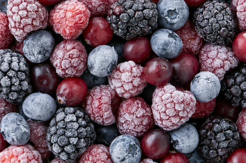 Overhead flat lay of mixed frozen berries covered in frost