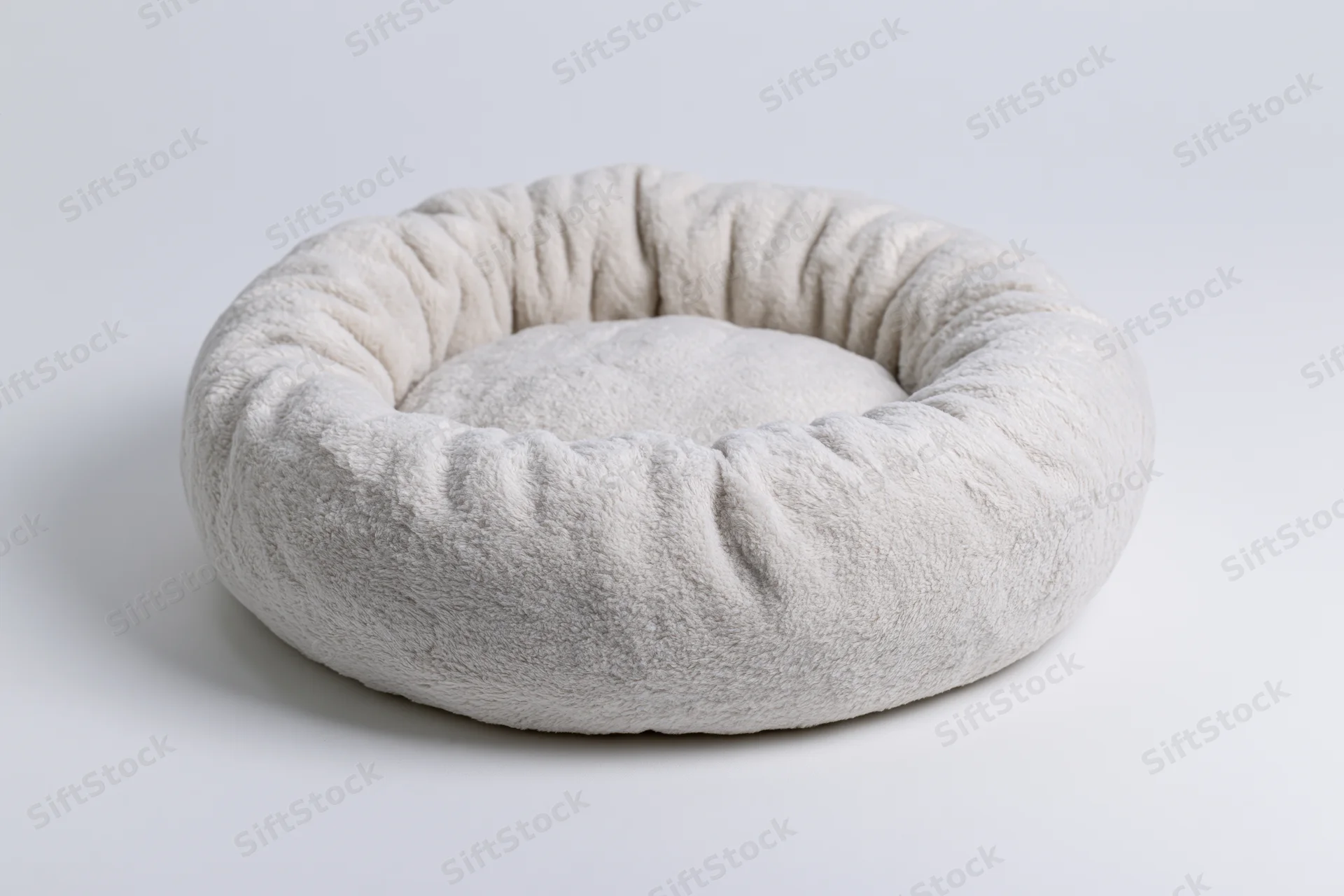 Round plush pet bed on plain white surface