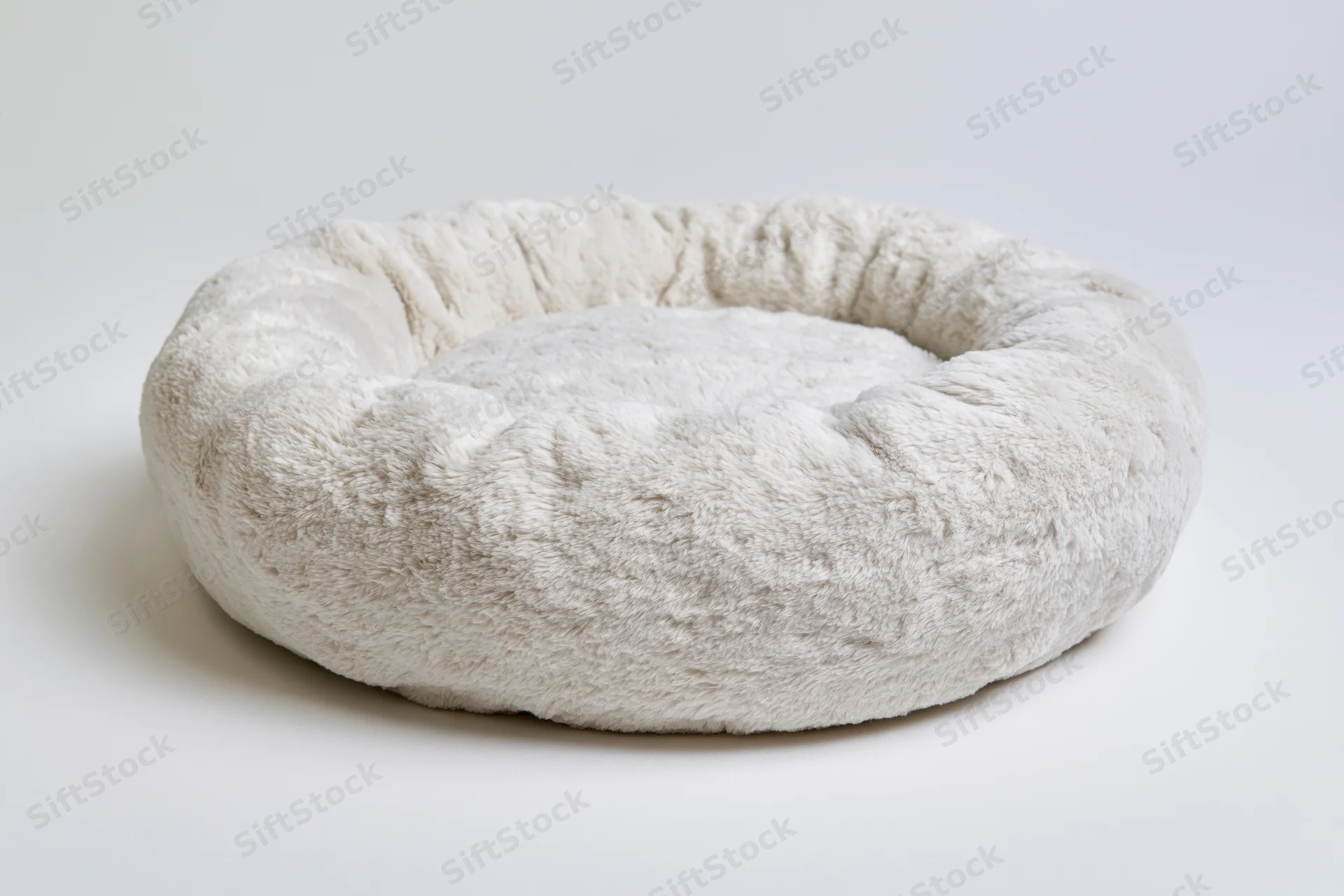 Round plush pet bed on plain white surface