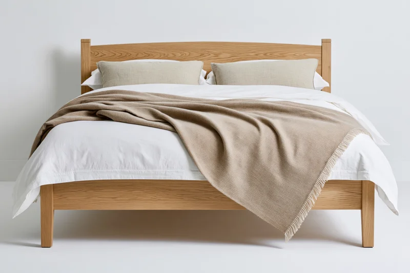 Double bed with light oak wooden frame and white bedding in minimalist setting