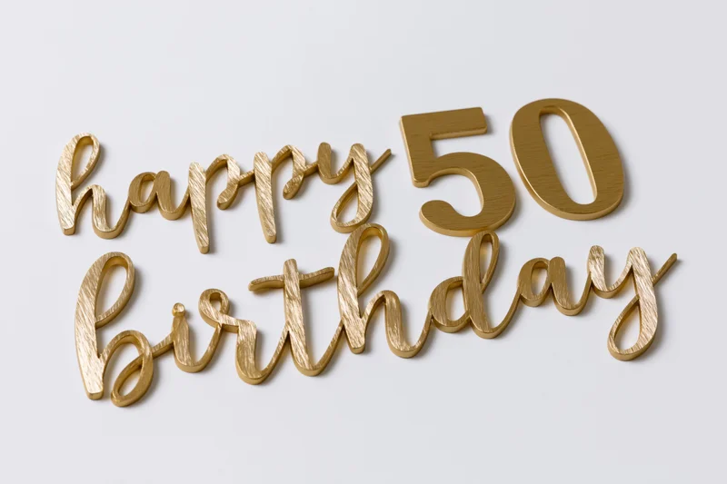 Golden 3d text reading happy 50 birthday arranged on white surface