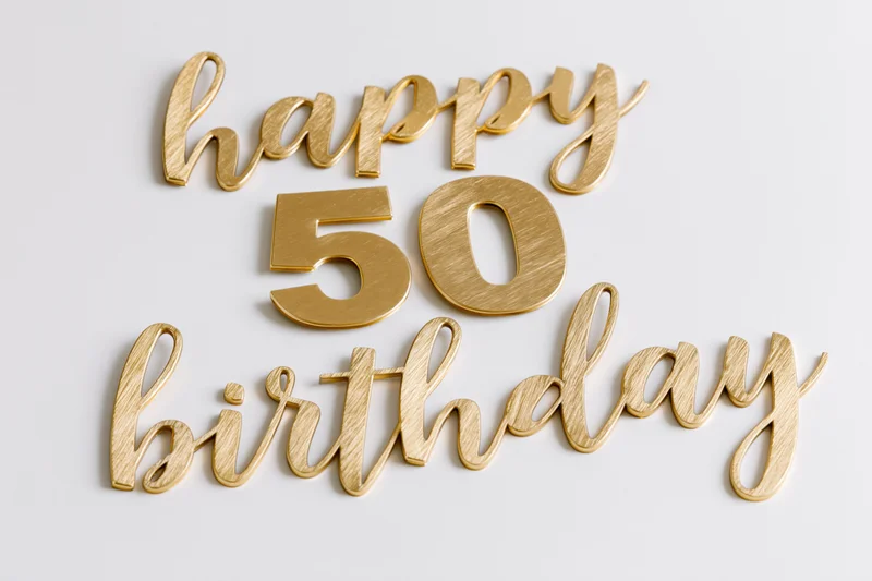 Golden 3d text reading happy 50 birthday arranged on white surface