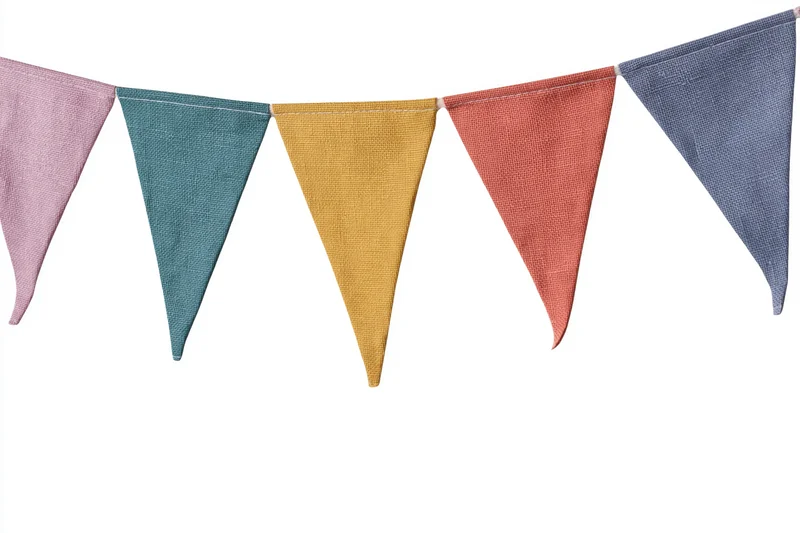Colorful fabric triangle bunting flags strung horizontally against white background