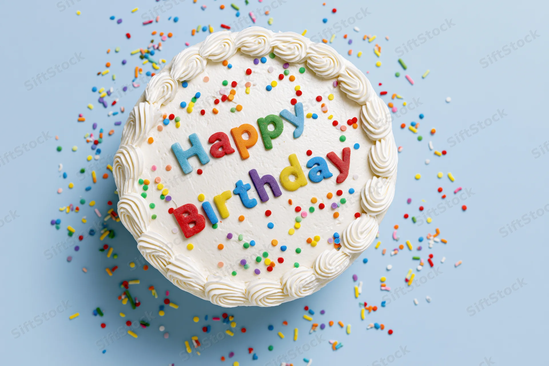 Round white-frosted birthday cake with colorful sprinkles and "Happy Birthday" letters on light blue background