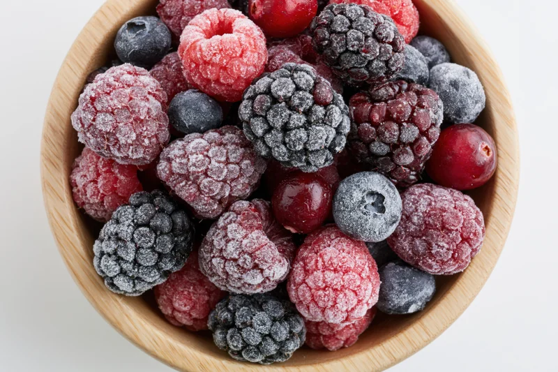 Frozen berries in a wooden bowl viewed from above