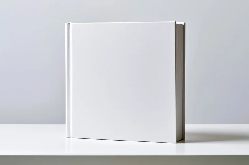 Blank white hardcover book standing upright on a white surface