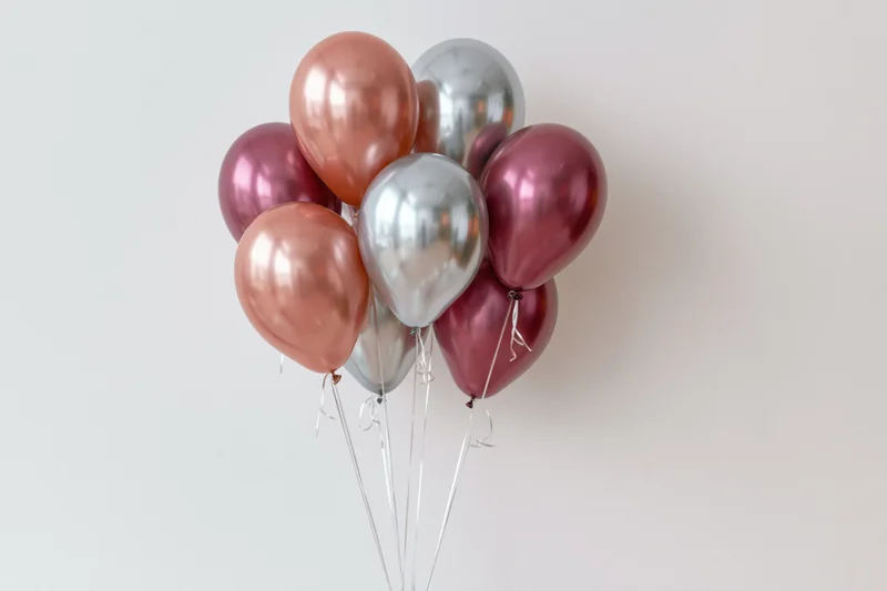 Metallic balloons clustered together against a white background with copyspace