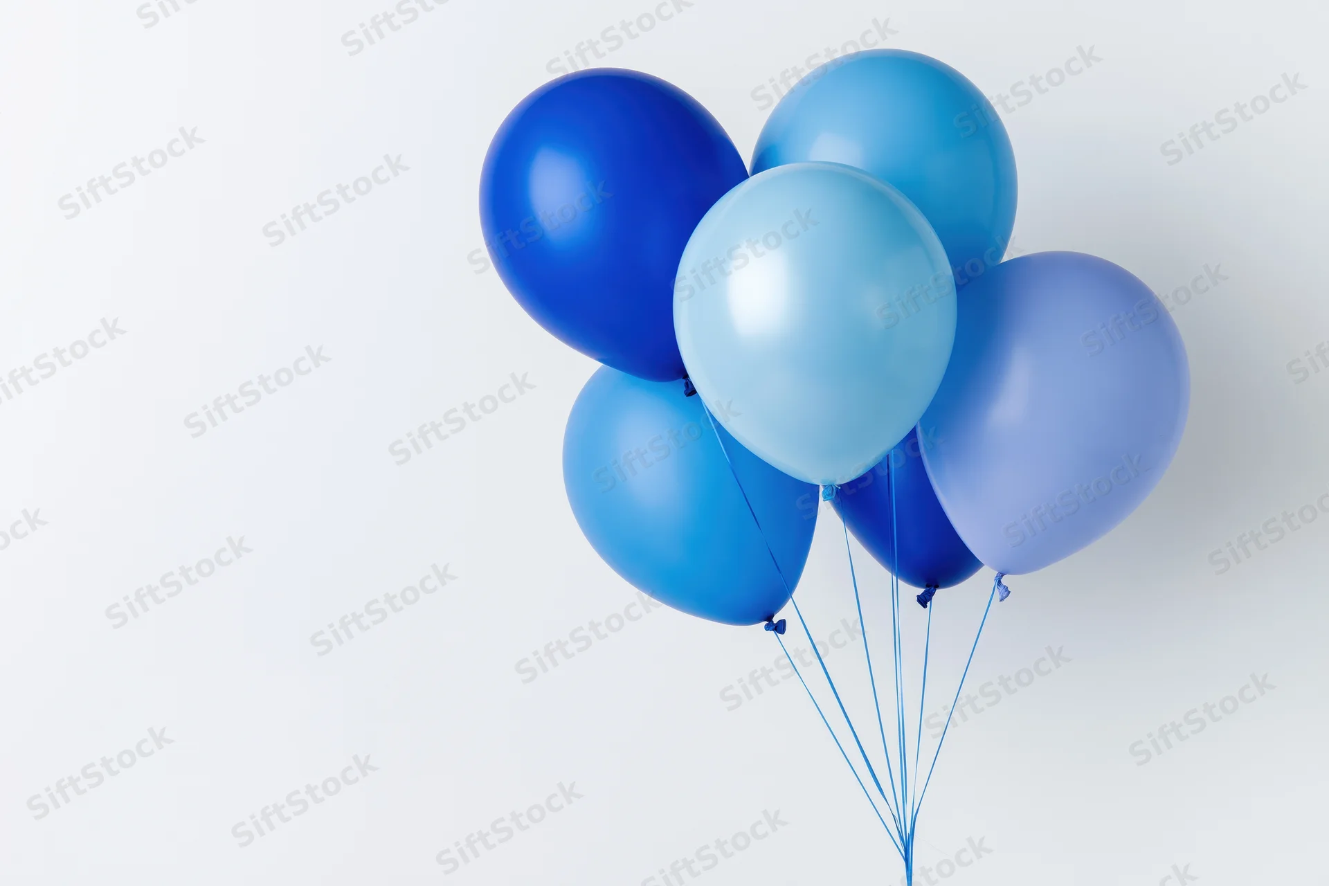 Cluster of blue helium balloons tied together against white background with copyspace