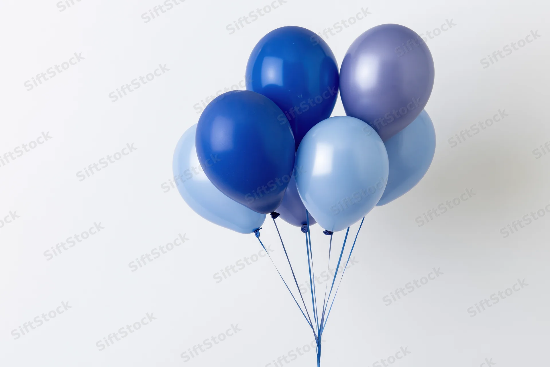 Cluster of blue helium balloons floating against white background with copyspace