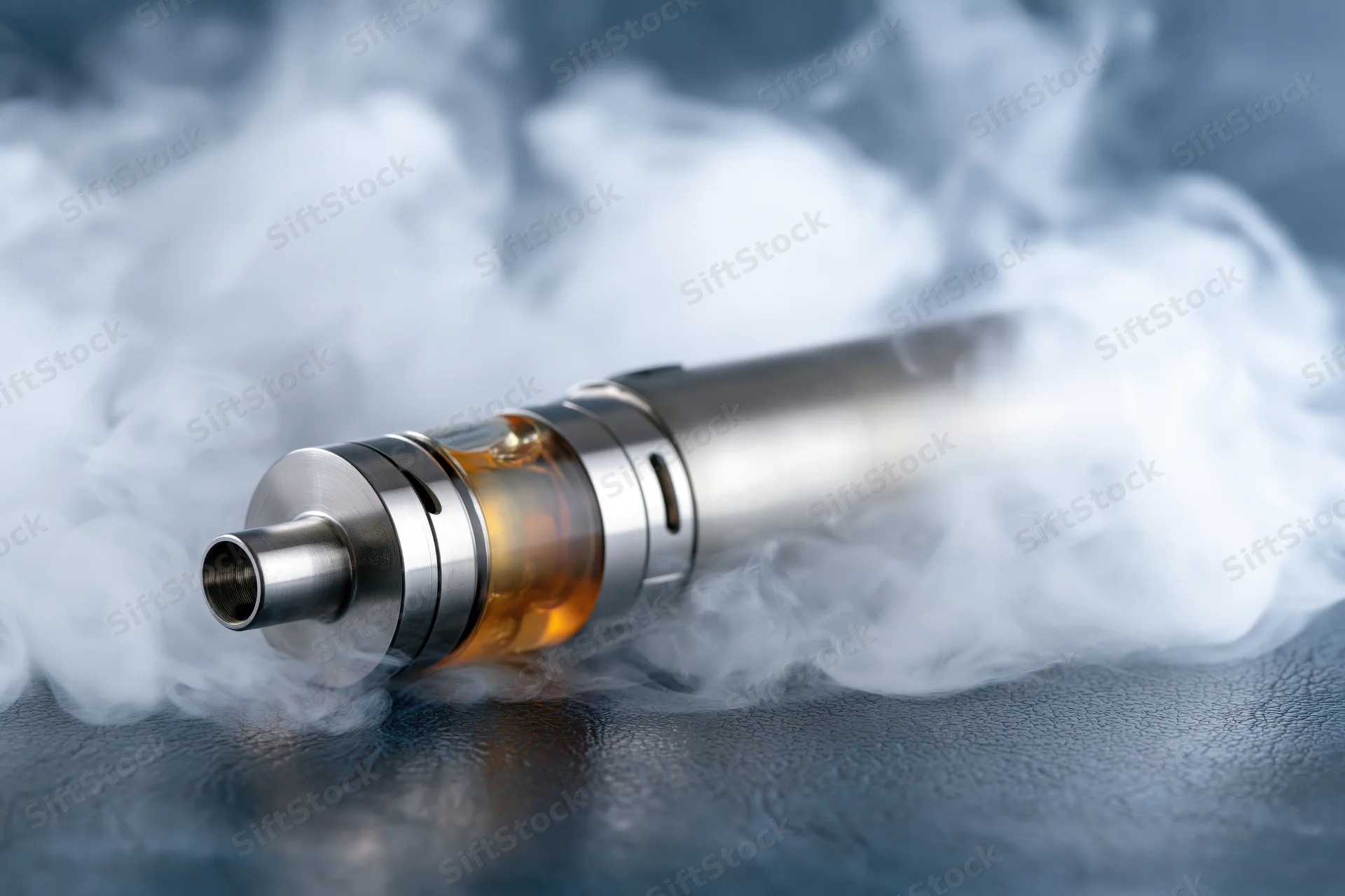 Cylindrical vape mod device lying on dark textured surface surrounded by vapor