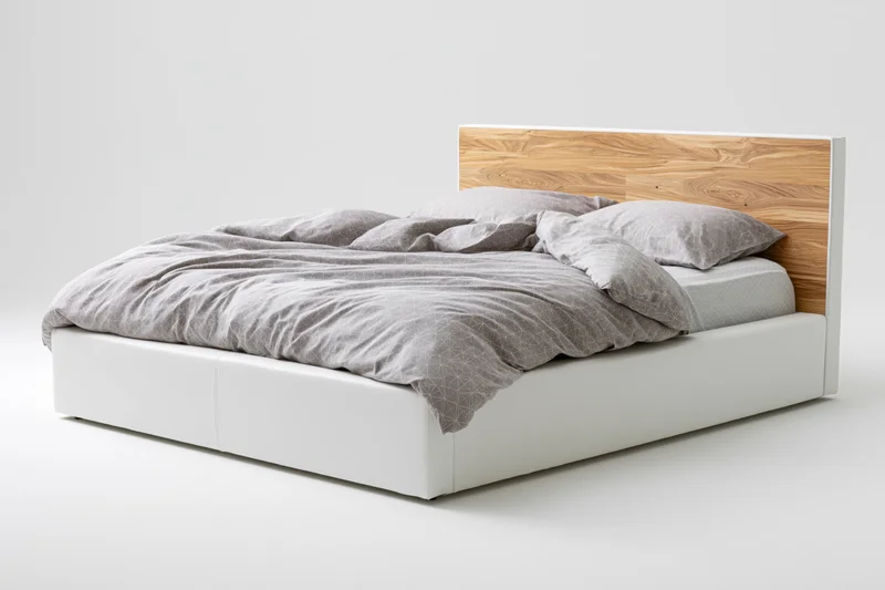 Double bed with white faux-leather frame and wooden headboard, gray bedding, studio setting