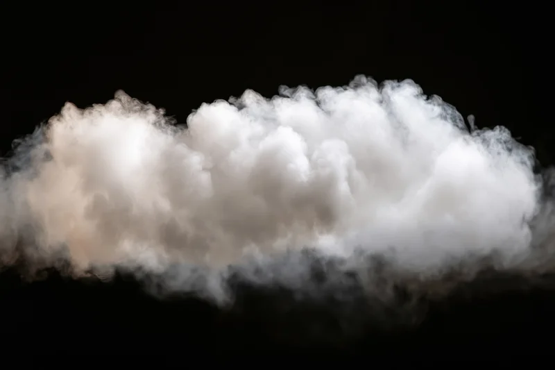 Horizontal wisp of white smoke drifting across black background