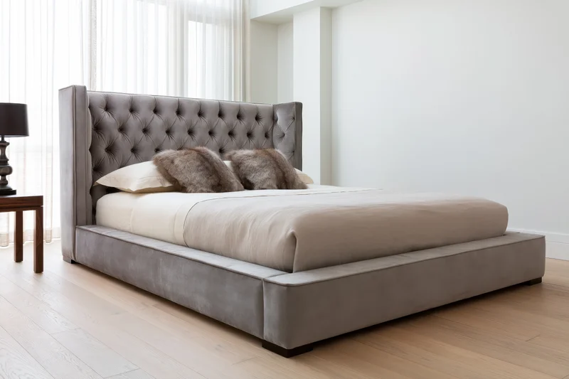 Large upholstered platform bed with tufted velvet headboard in a modern bedroom