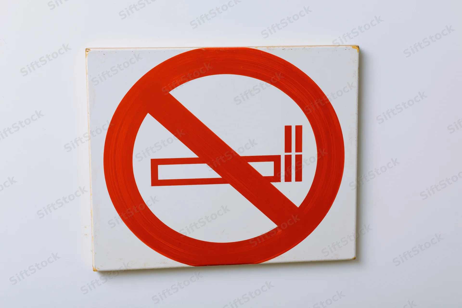 No-smoking prohibition sign with red circle and diagonal slash on white background