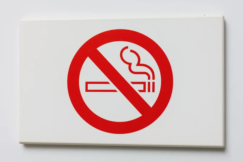 No-smoking prohibition sign with red circle and diagonal slash on white background