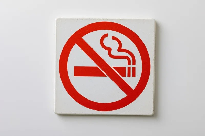 No-smoking prohibition sign with red circle and diagonal slash on white background
