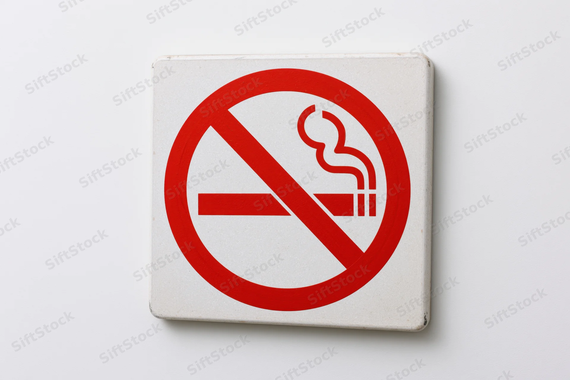 No-smoking prohibition sign with red circle and diagonal slash on white background