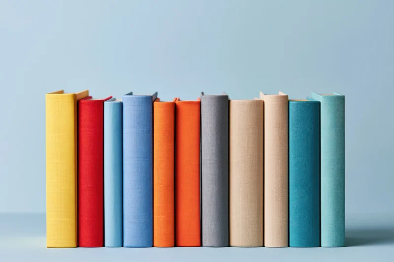 Row of colorful hardcover books standing upright on a flat surface
