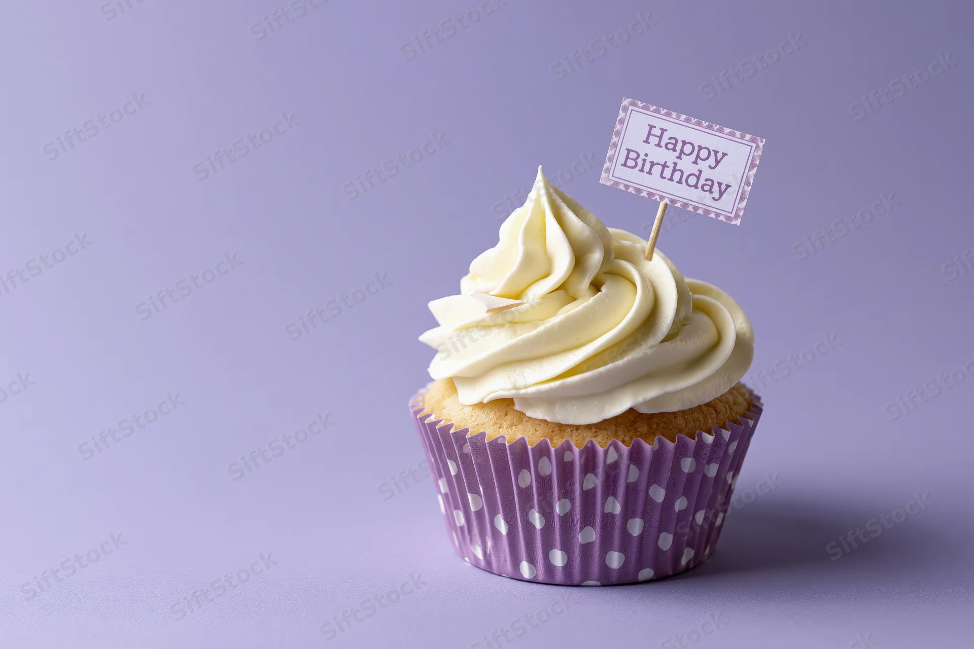 Single cupcake with white frosting and happy birthday topper on purple background