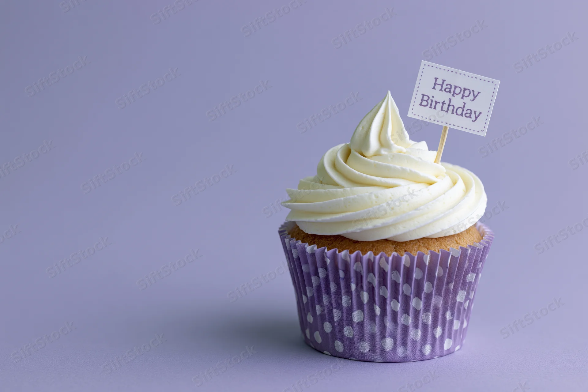 Single cupcake with white frosting and birthday topper on purple background