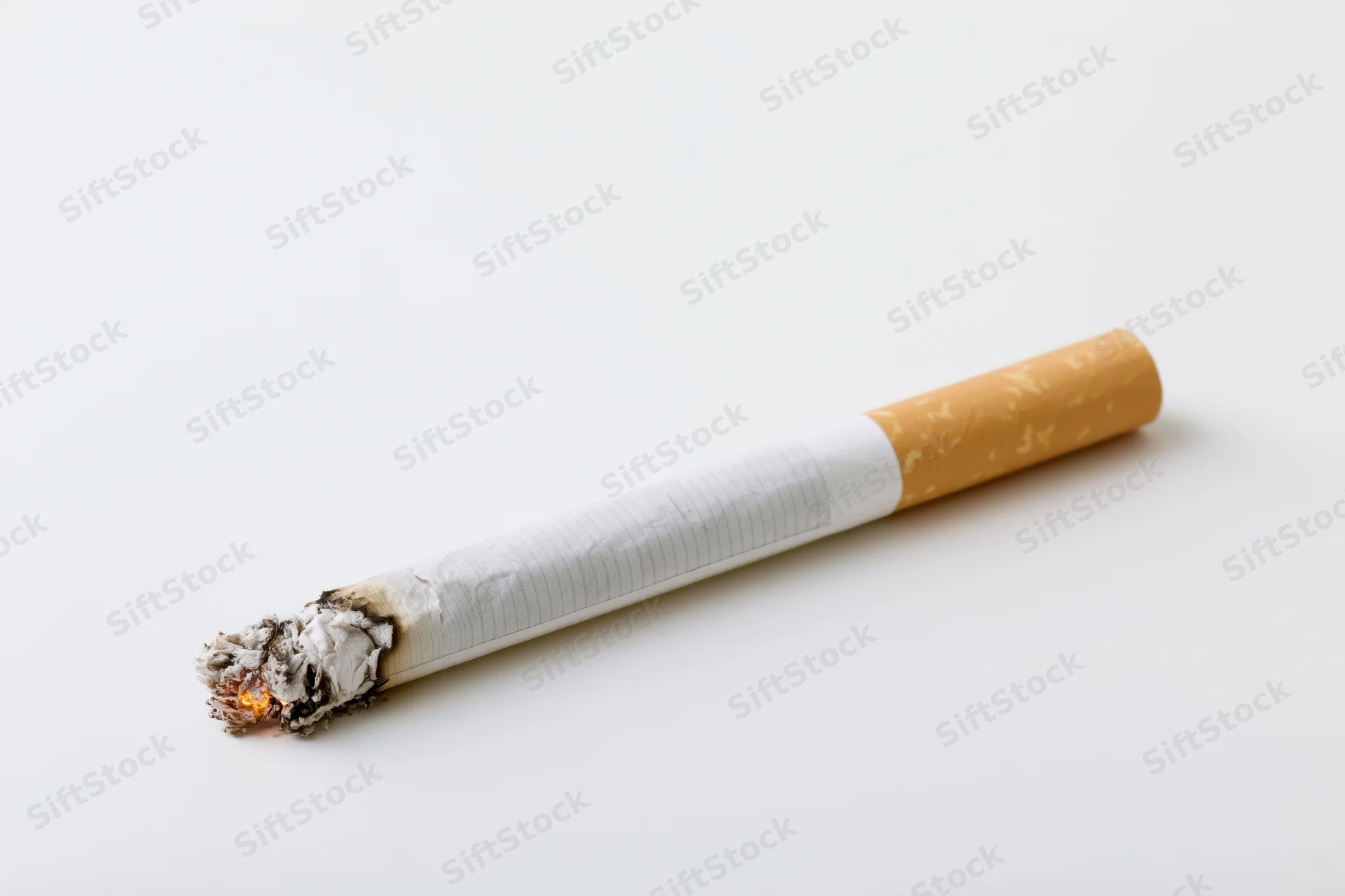 Lit cigarette with glowing ember and ash on white background