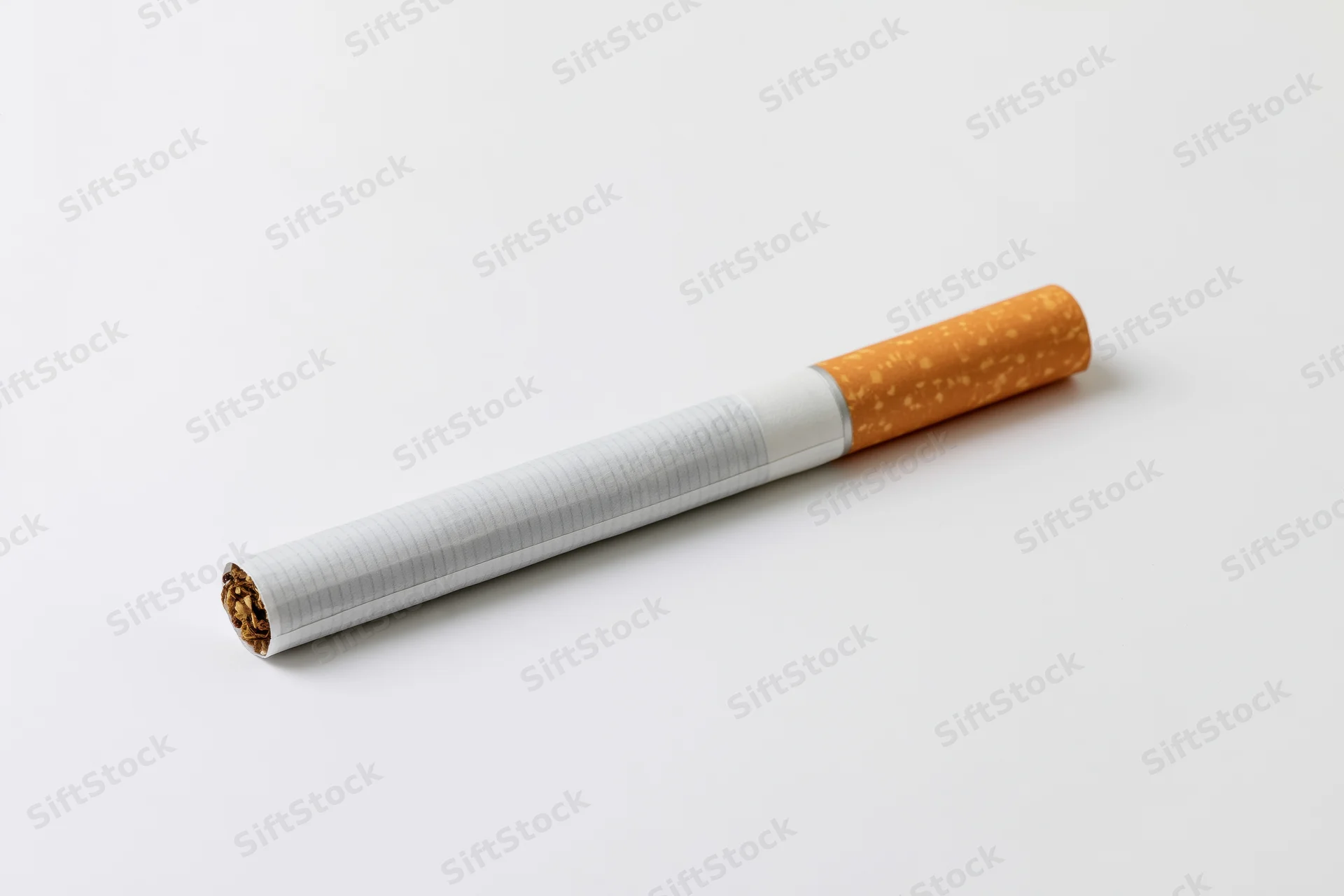 Unlit cigarette lying horizontally on plain white paper
