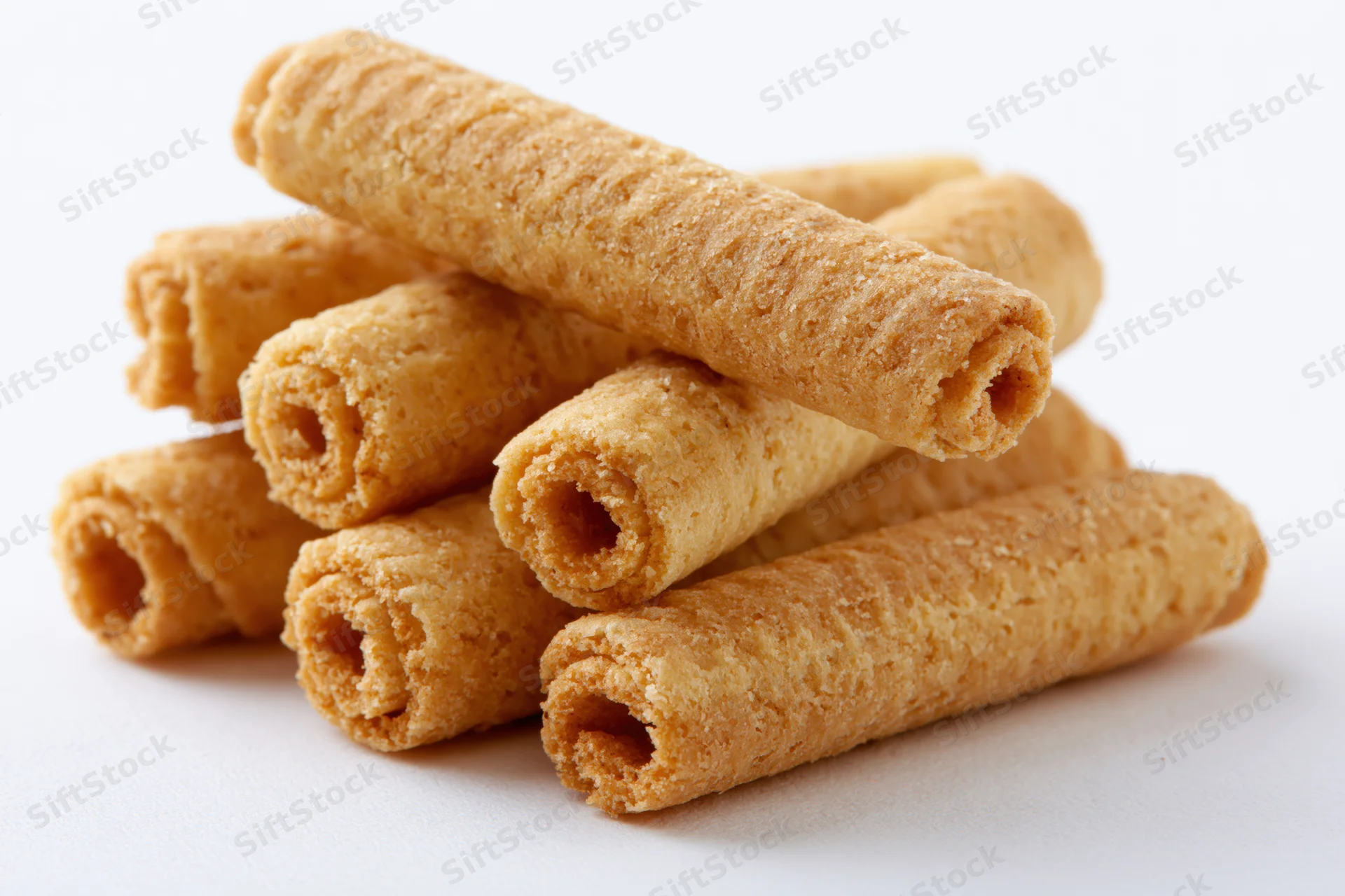 Stack of crispy rolled wafer biscuits on white background