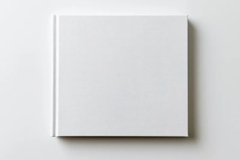 Square blank white hardcover book lying flat on a clean white surface