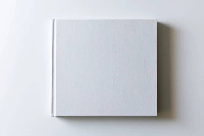 Square blank white hardcover book lying flat on a clean white