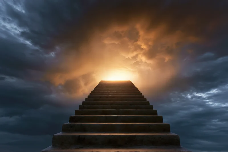 Stone staircase ascending through dramatic clouds toward a glowing horizon