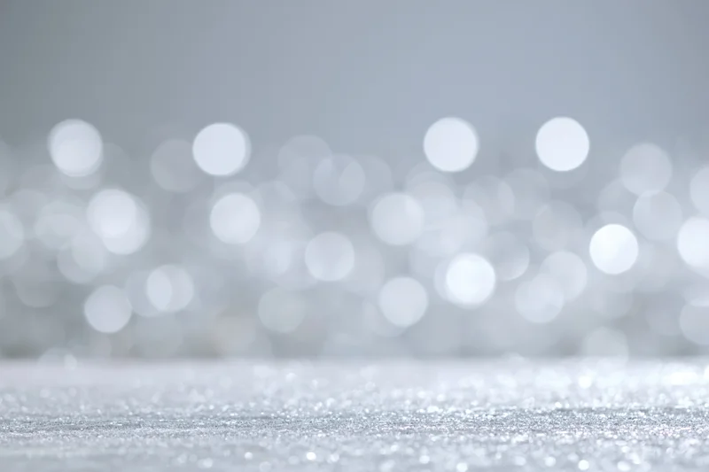 Silver glitter surface with blurred bokeh lights in background