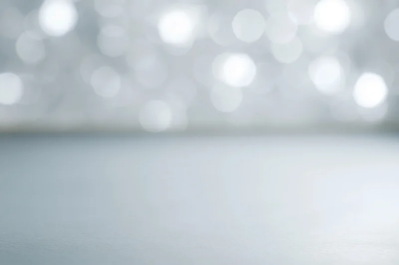 Soft white bokeh lights over a smooth surface as a festive background