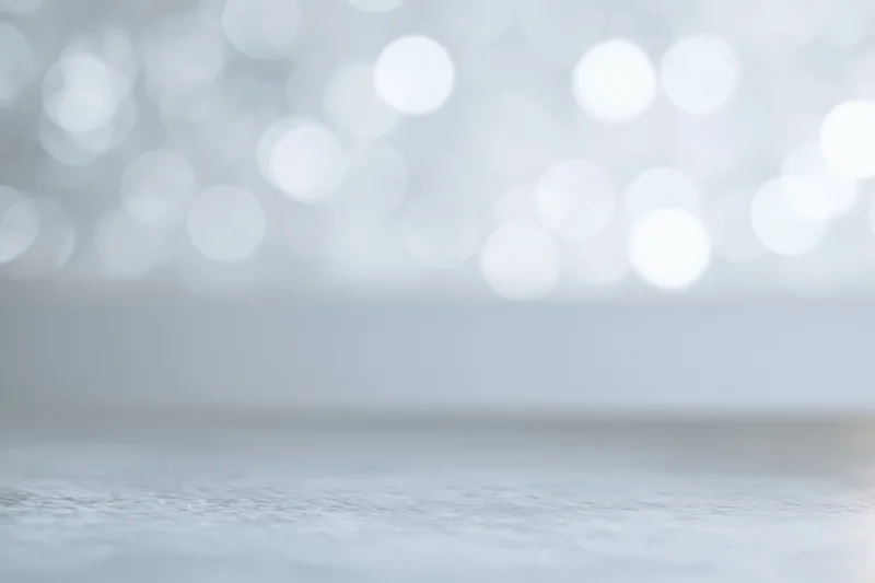 Soft white bokeh lights blurred in background above smooth surface