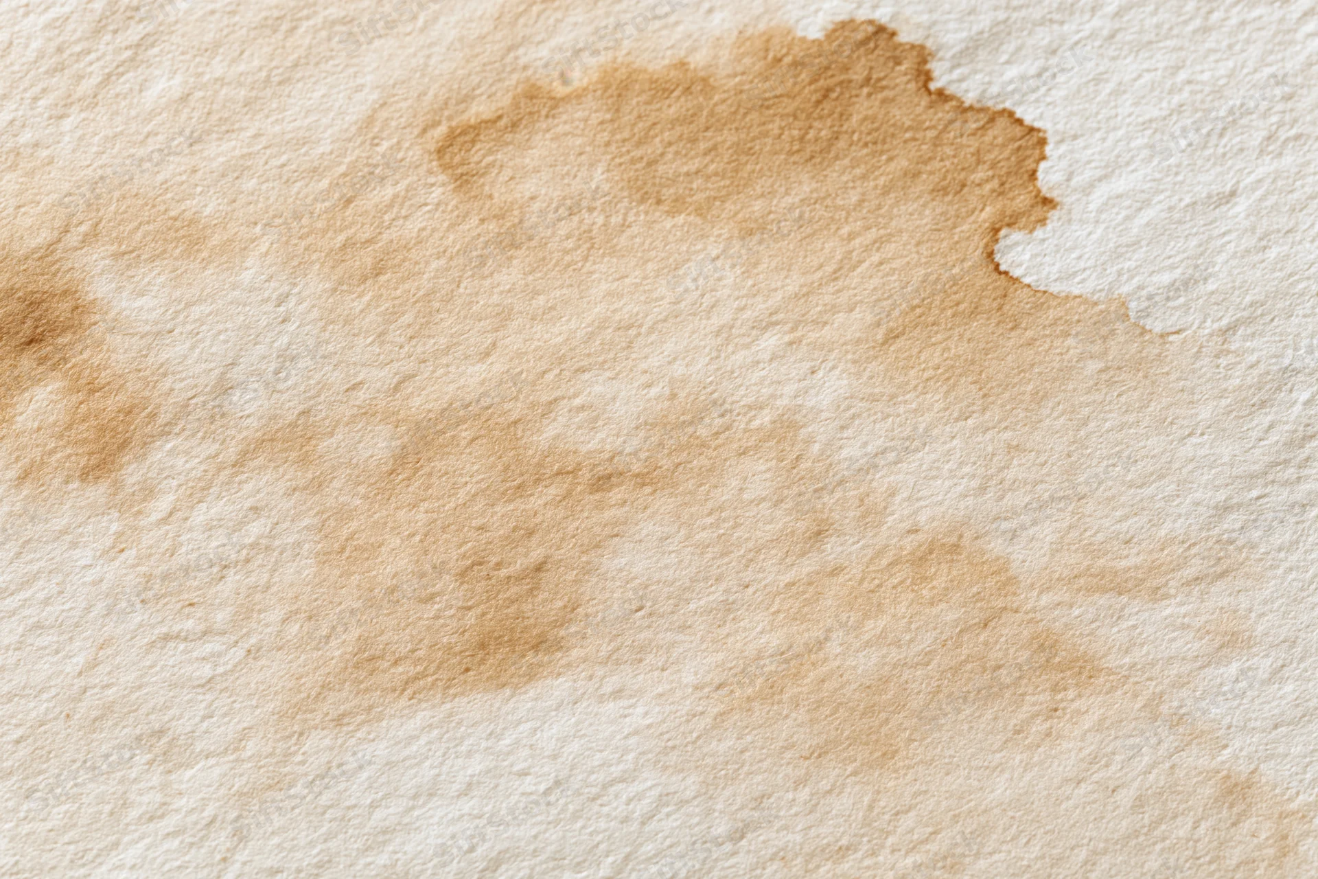 Aged paper surface with uneven brown water stains and textured fibers