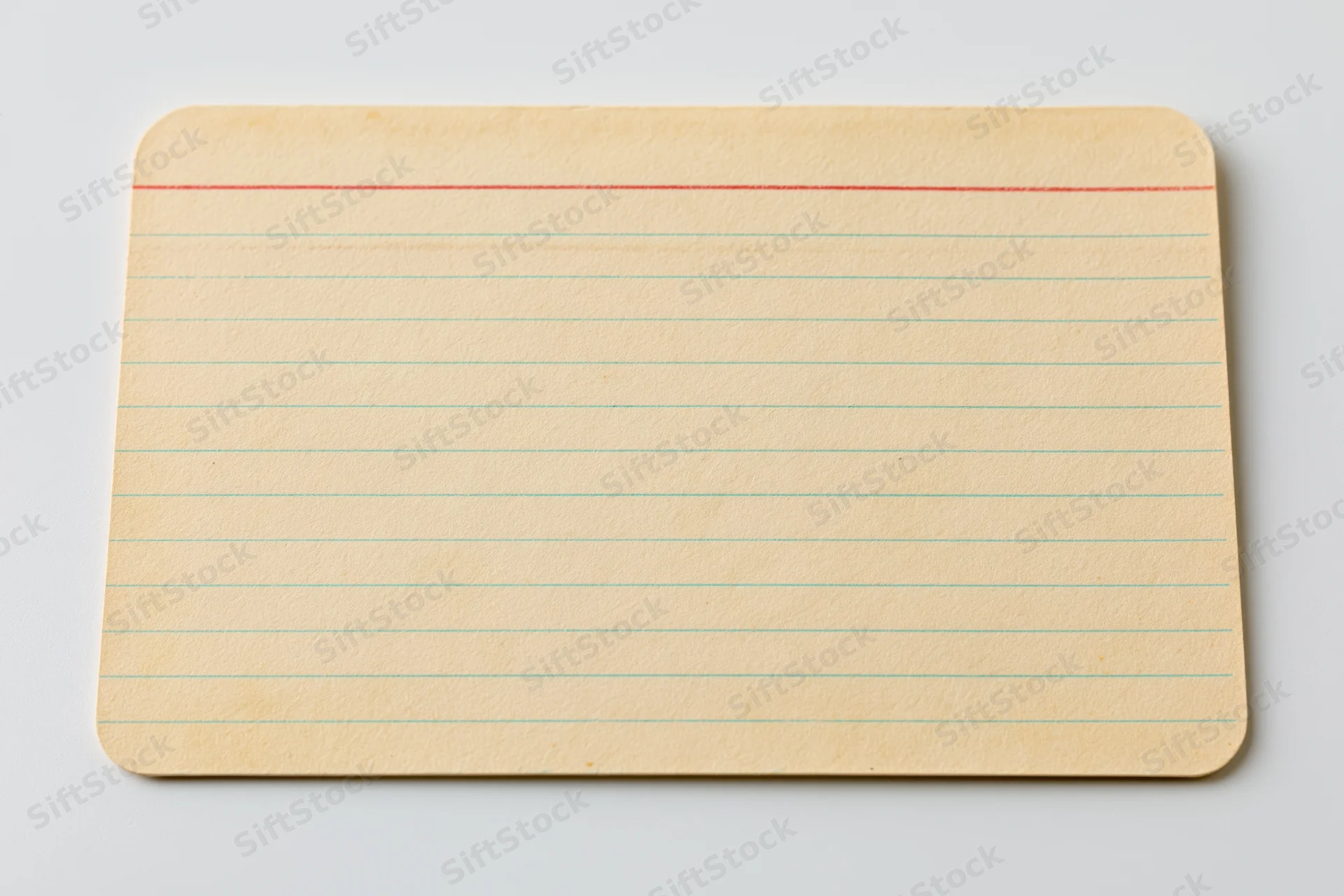 Vintage blank index card with red and green lines lying flat on white surface