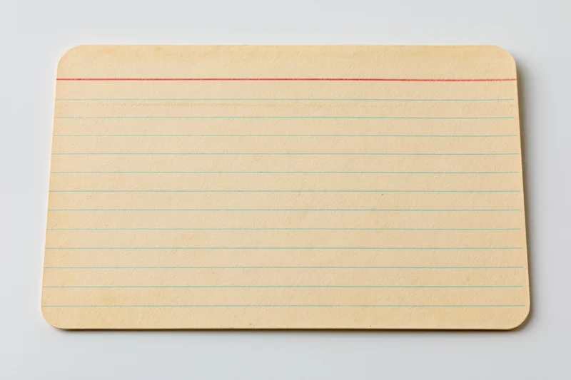 Vintage blank index card with red and green lines lying flat on white surface