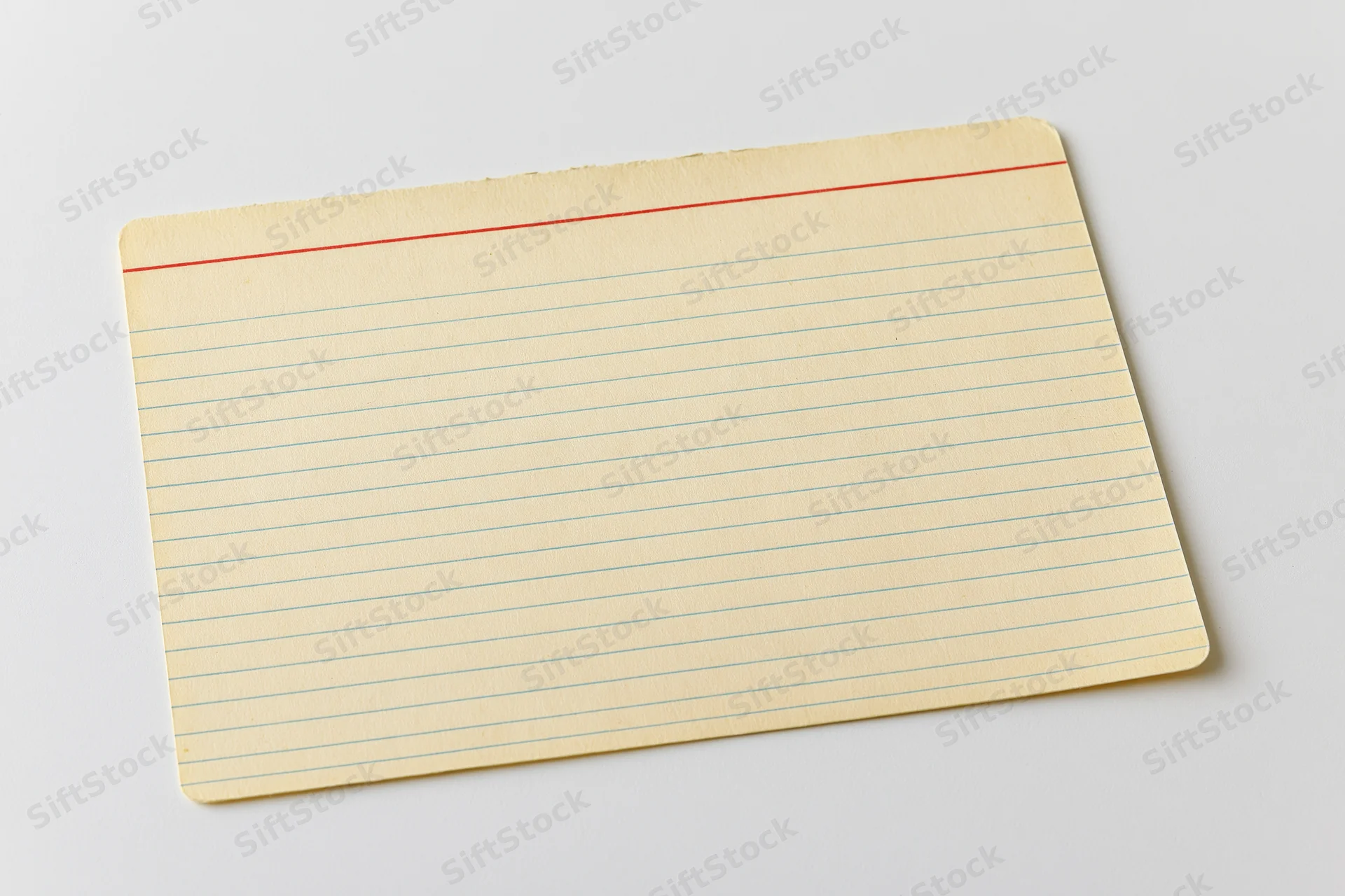 Vintage blank index card with blue lines and red margin line lying flat on white surface