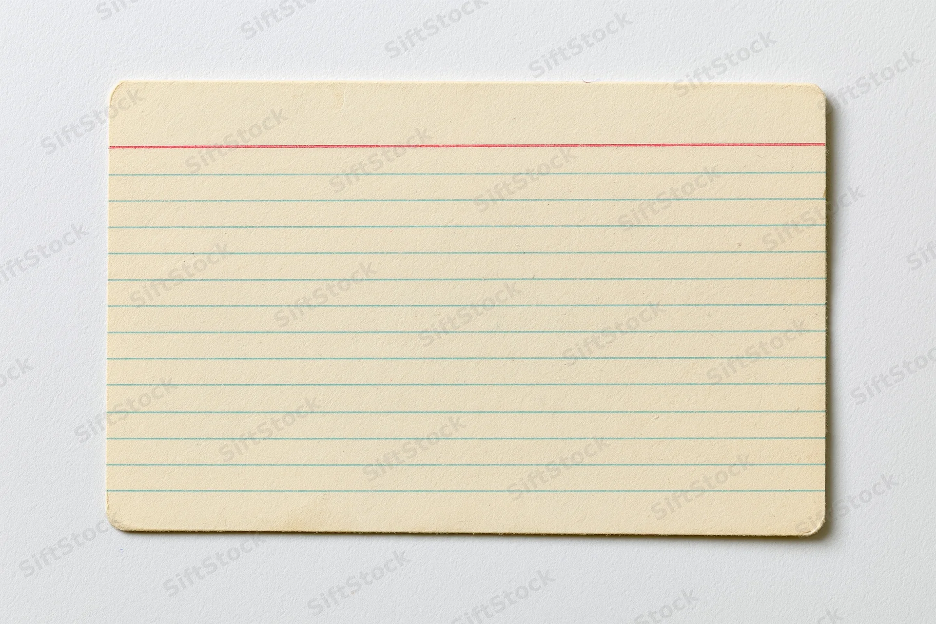 Vintage blank index card with red and blue lines lying flat on white surface