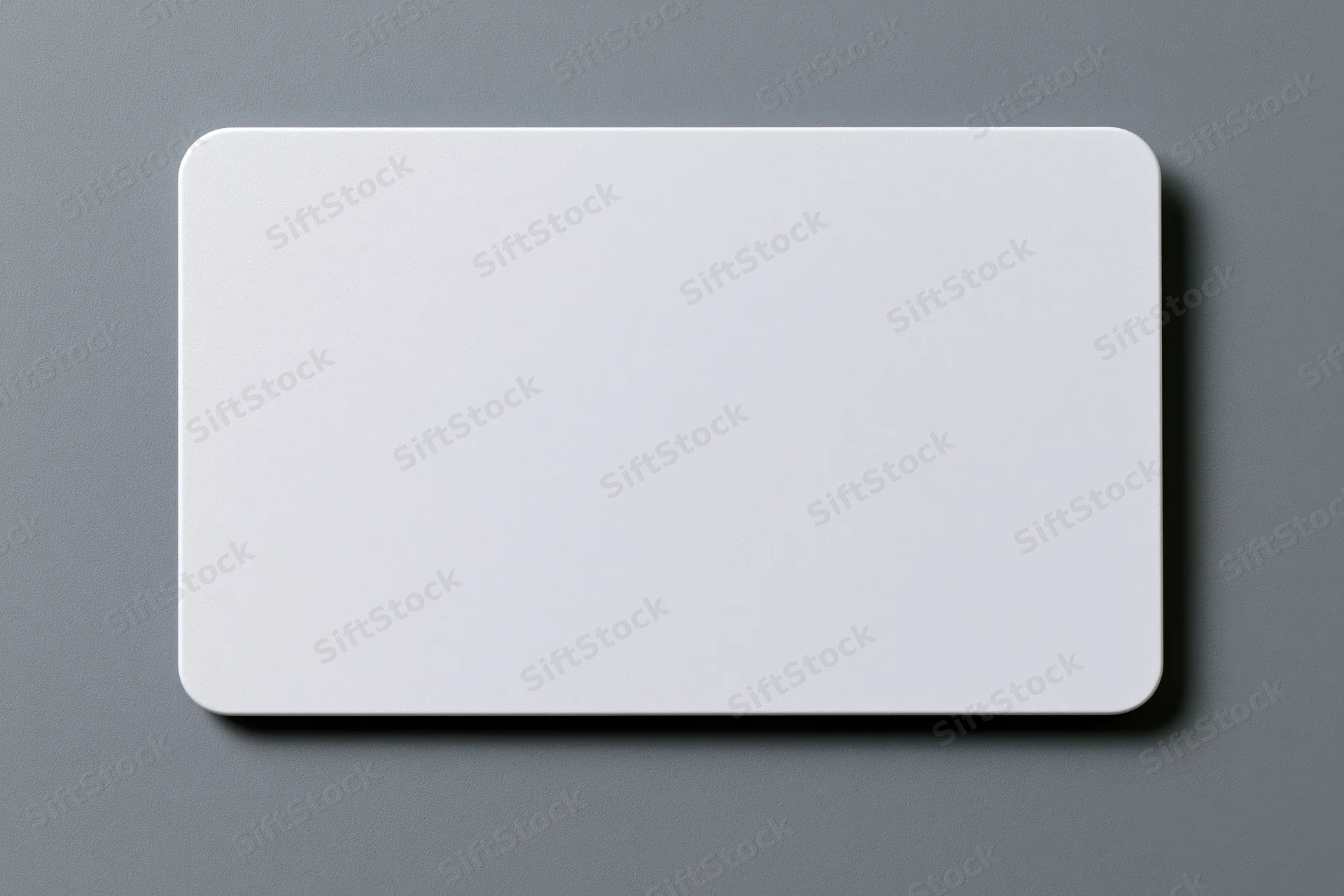 Blank white plastic card with rounded corners lying flat on gray surface